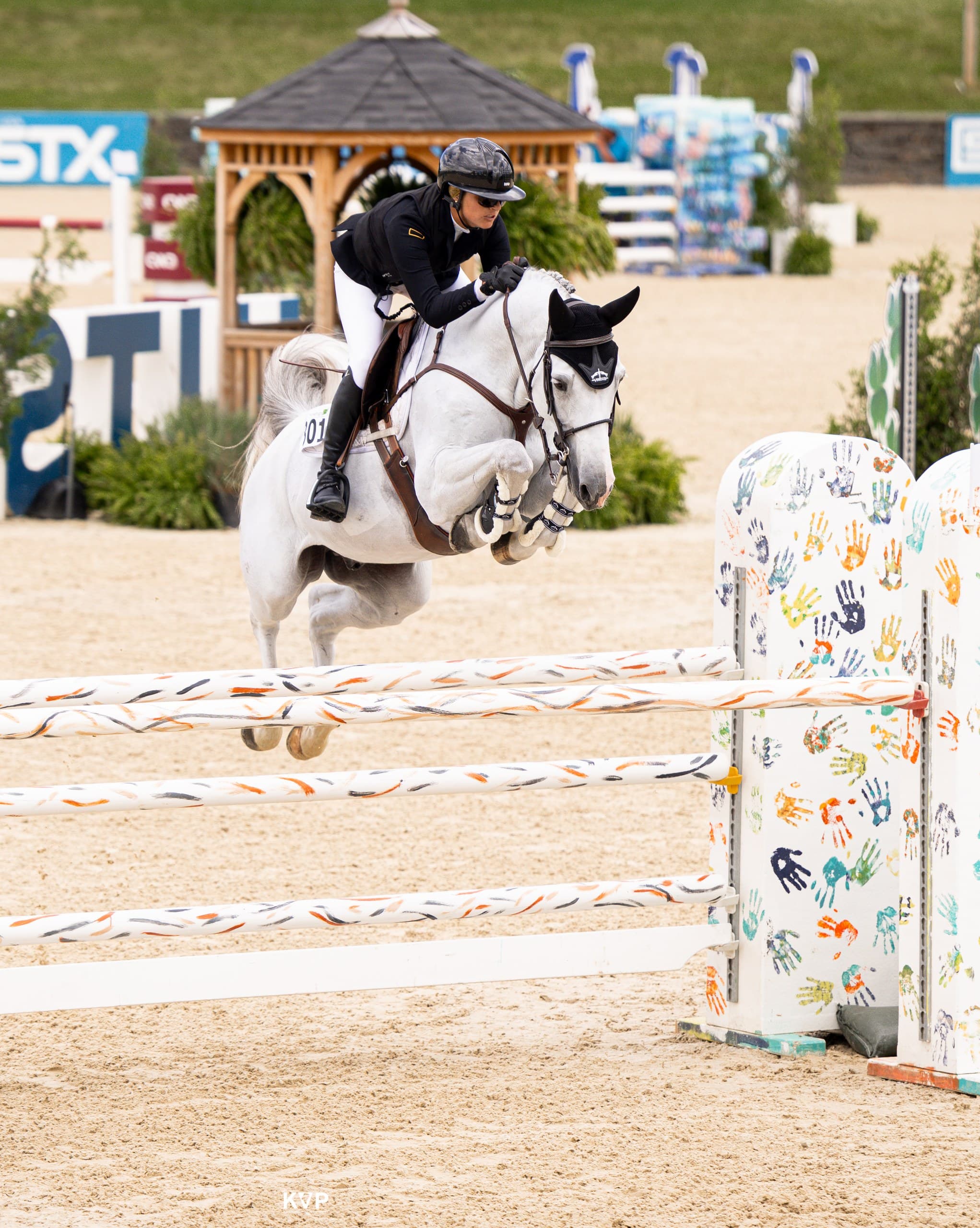 Emma Marlowe riding a grey horse in competition